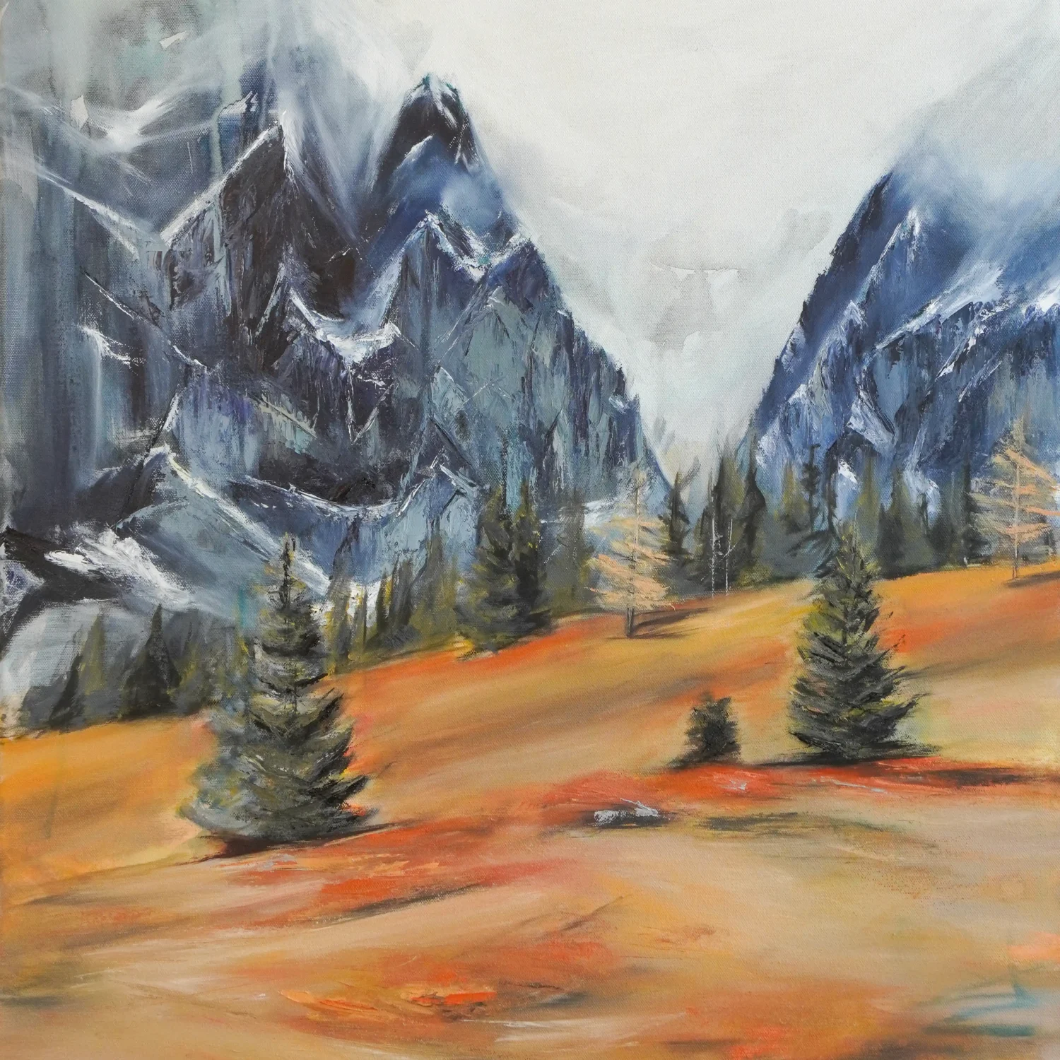 Ölgemälde von Alexandra Hörhager aus der 12-Monate-Serie: eine Vorfrühlings-Berglandschaft mit nebelverhangenen, schroffen Felsgipfeln in Blaugrau und einer warmen ocker-orangefarbenen Wiese mit einzelnen Nadelbäumen im Vordergrund.